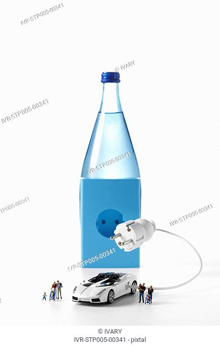Close-up of electric toy car in front of bottle socket on white background