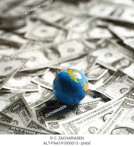 Small world globe on top of U S Dollars
