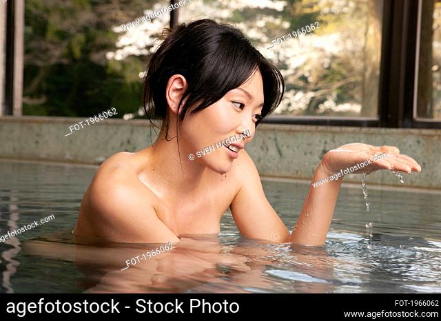 Young woman soaking in pool at Onsen spa