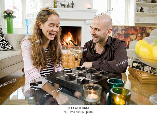 Man and girl at home playing a parlour game, Sweden
