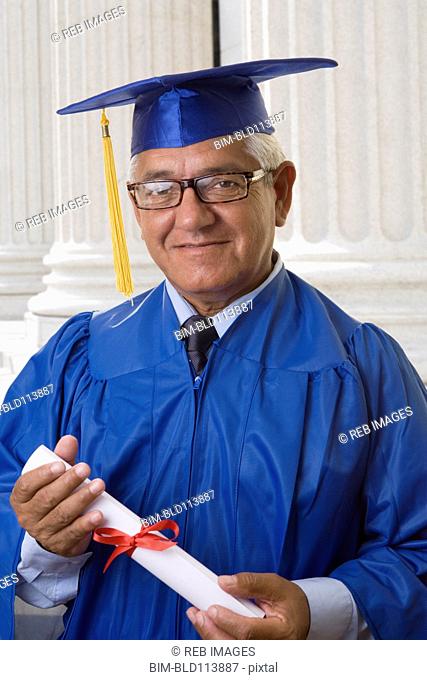 Hispanic man receiving college diploma