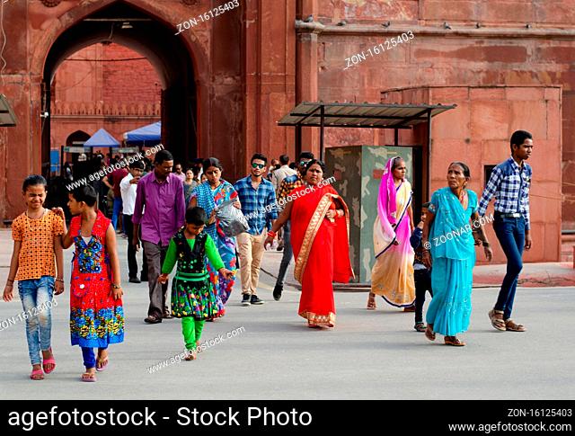 Asian people with colorful traditional costumes walking outside the famous red fort in New Delhi India
