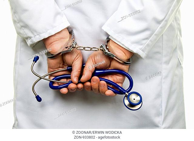 Arzt mit Stethoskop und Handschellen