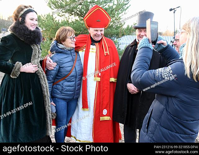 16 December 2023, Saxony, Schkeuditz: St. Nicholas (M) is the most popular photo subject at the Victorian Christmas market at Biedermeierstrand in Hayna near...