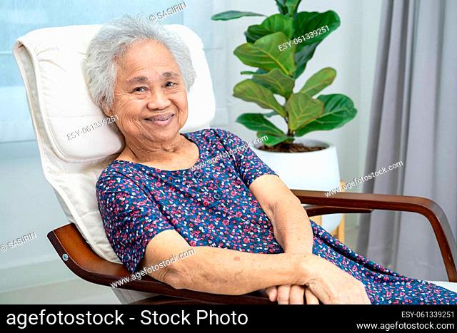 Asian elderly woman sitting and relaxing with happy in rocking chair at room in home