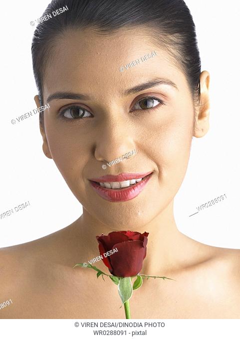 South Asian Indian woman smiling holding and smelling red rose MR 702