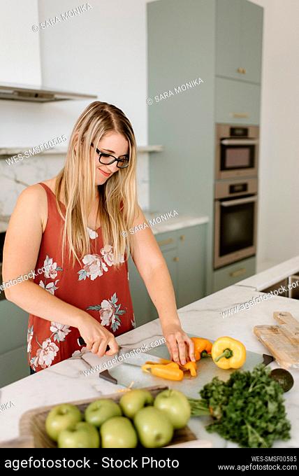 Female dietician cutting vegetable in kitchen