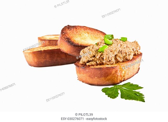 Fried bread with liver pate, green onions and parsley leaves on a white background