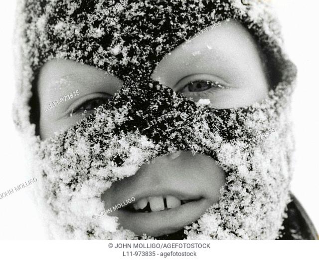 Close-up of boy in ski mask, covered with snow
