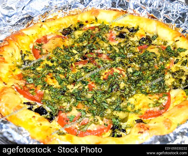 Pizza with tomatoes sprinkled with herbs and grated cheese. Cooking pizza