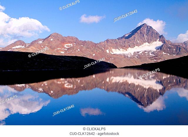 Mountains of Gavia pass reflected in a small alpin lake, Lombardy, Italy, Europe