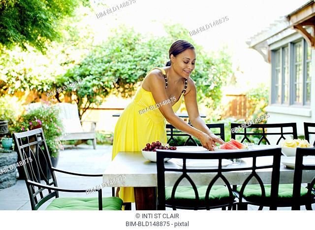 African American woman preparing lunch on patio