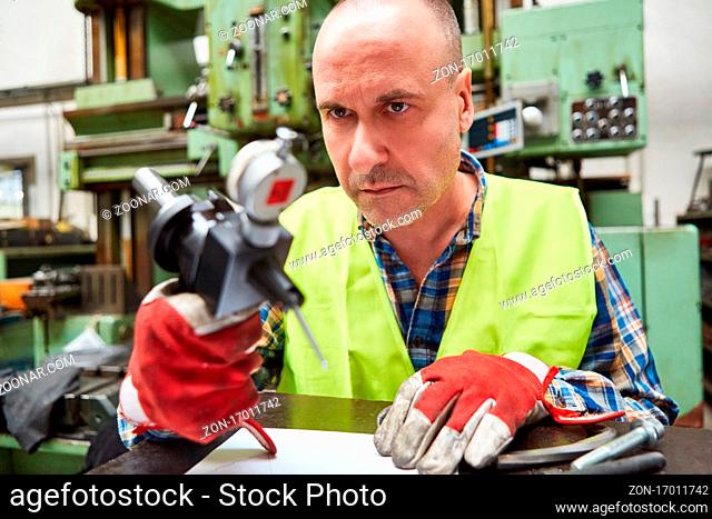 Arbeiter als Metallarbeiter mit Werkzeug in der Schlosserei der Fabrik für Metallbau