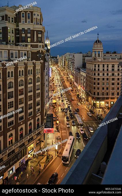 In summer Madrid is filled with tourist to visit its streets, in this case: the street Gran Via at night and with a los of traffic