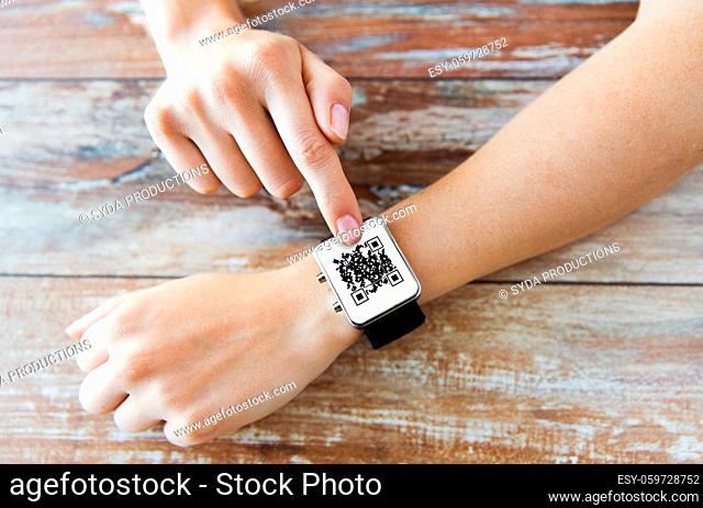 woman's hands with qr code on smart watch
