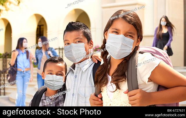 Young students on school campus wearing medical face masks