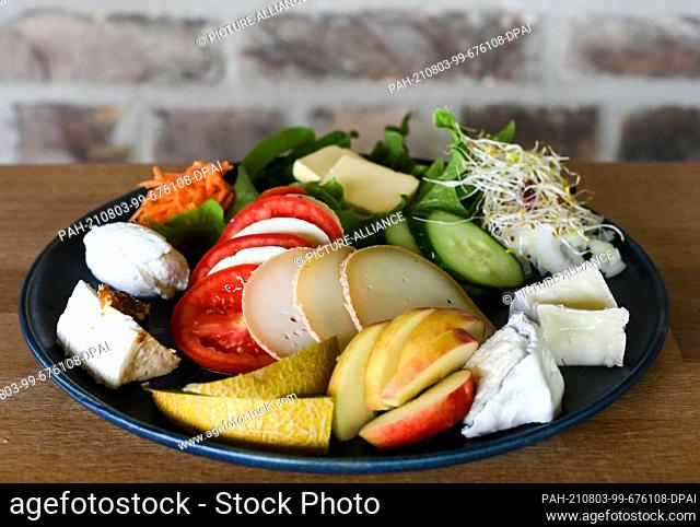 30 July 2021, Brandenburg, Flatow: A plate is decorated with different types of cheese from the Karolinenhof goat dairy near Kremmen