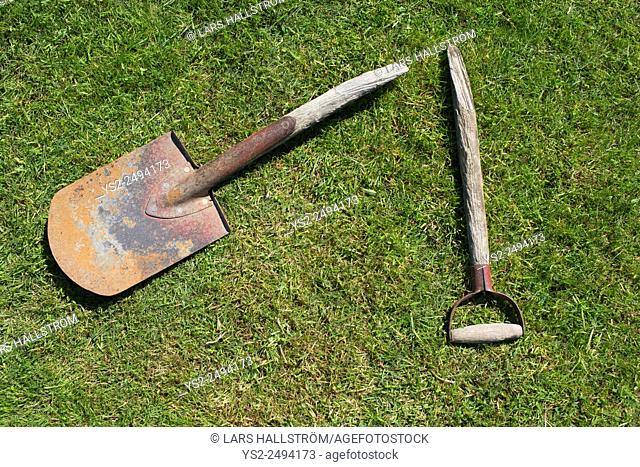 Broken garden shovel lying on green grass