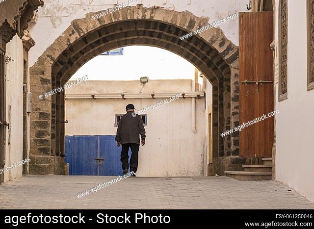 old man passing under the arches of the medina, Essaouira, morocco, africa