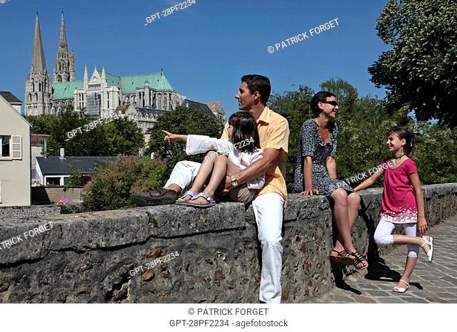 FAMILY SITTING ON A BRIDGE OVER THE EURE RIVER WITH THE CATHEDRAL IN THE BACKGROUND, OLD TOWN OF CHARTRES, EURE-ET-LOIR 28, FRANCE