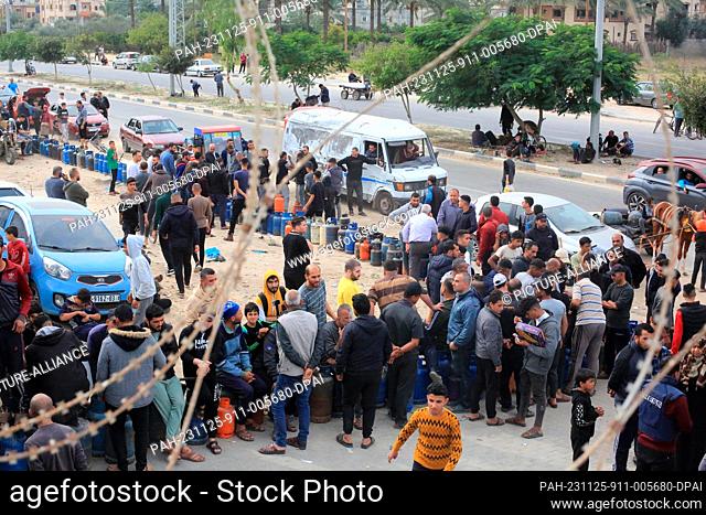 25 November 2023, Palestinian Territories, Khan Yunis: Palestinians queue to refill their liquid gas cylinders, on the second day of a four-day cease fire...