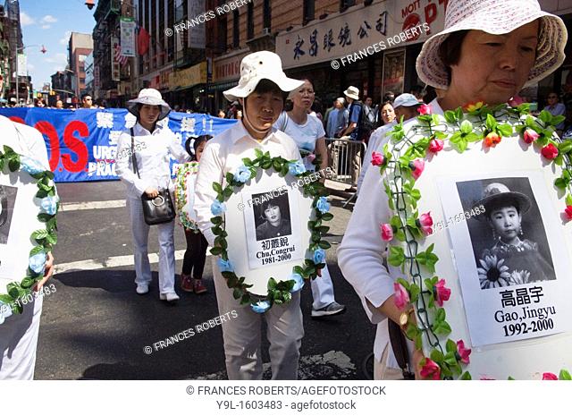 Carrying banners and signs members of Falun Dafa Falun Gong from around the world parade through the streets of Chinatown in New York Practitioners of Falun...