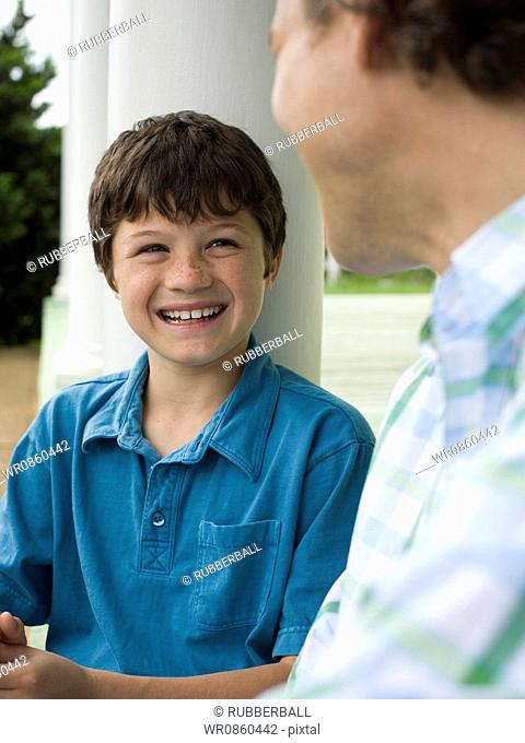 Close-up of a boy and his father smiling