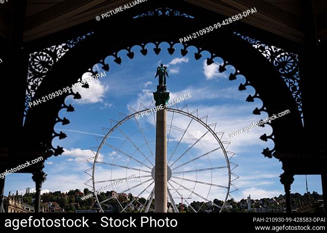30 September 2021, Baden-Wuerttemberg, Stuttgart: A Ferris wheel, which is still missing the gondolas and the jubilee column on the Schlossplatz can be seen...