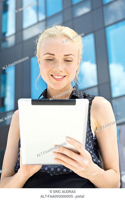 Young woman using digital tablet outdoors