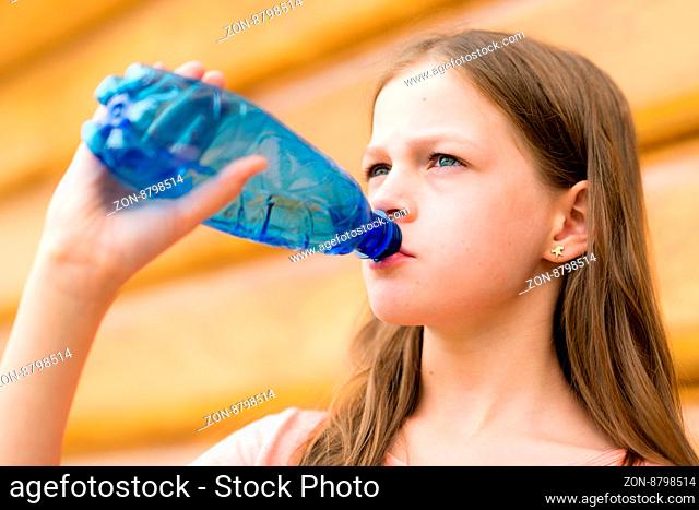 Girl drinking water outdoors - very shallow depth of field