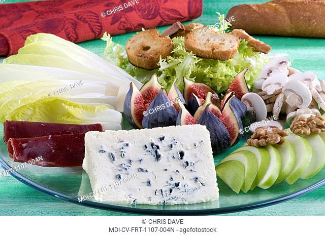 Plate of Saint-Agur cheese, endive and curly endive, fresh fig, Paris mushroom, apple, bindenfleisch and wallnuts