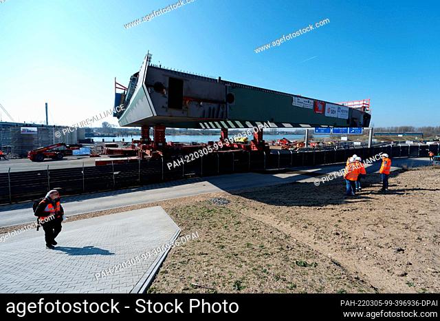 05 March 2022, Cologne: The first steel component for the New Bridge of the A1 over the Rhine near Leverkusen is hazed to the concrete girders of the bridge and...