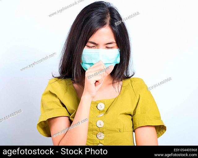 Portrait Asian beautiful happy young woman wearing face mask protects filter dust pm2.5 anti-pollution, anti-smog, and air pollution her sneezing in mask on a...