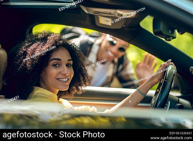 Hitchhiker. Young man and woman talking on the road and smiling