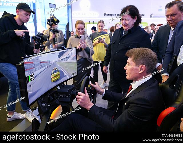 RUSSIA, MOSCOW - NOVEMBER 11, 2023: Primorye Region Governor Oleg Kozhemyako (seated) tries out a car racing video game at the opening of Kamchatka Region Day...