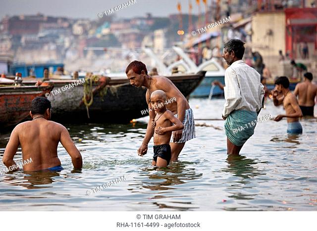 Indian Hindu pilgrims bathing in The Ganges River at Dashashwamedh Ghat in Holy City of Varanasi, Benares, India