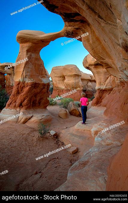 USA, Colorado Plateau, Utah, The Devil '?s Garden of the Grand Staircase-Escalante National Monument, woman hiking at Metate arch MR