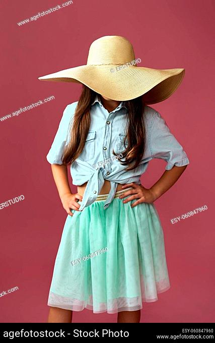 fashionable little child girl in hat isolated on pink background
