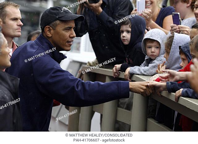 United States President Barack Obama (L) shakes hands with onlookers in front of Nancy's Restaurant in Oak Bluffs, Massachusetts on the island of Martha's...
