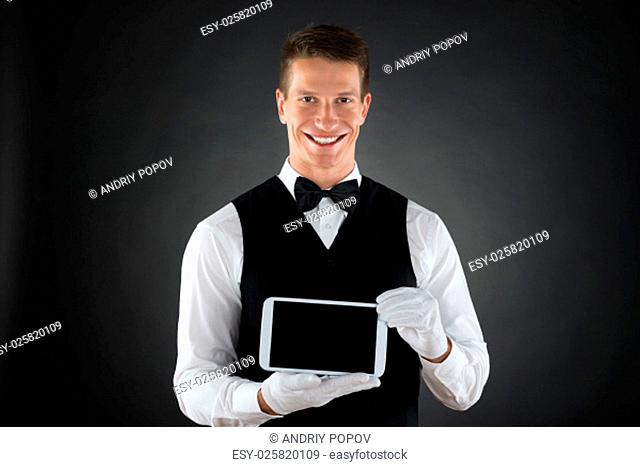 Portrait Of Young Happy Waiter Holding Cellphone