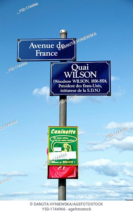 Post with street name plates of main streets localised next to Geneva Lake shore and dispenser of sanitary bags for dogs, Geneva, Switzerland