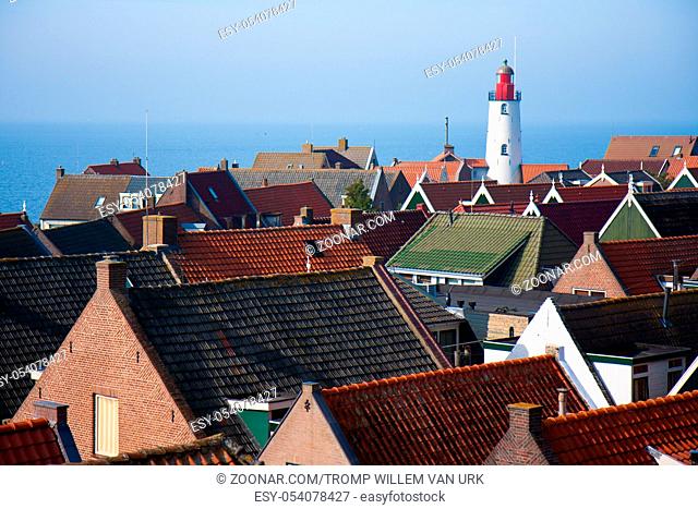 View at the lighthouse and roofs of a pittoresk old fishing village in the netherlands