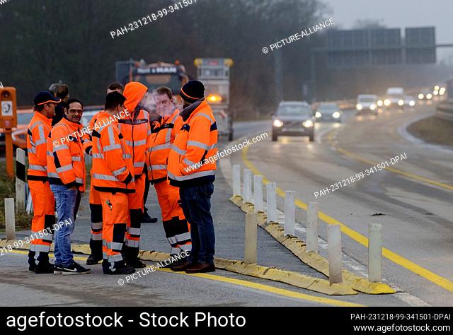 18 December 2023, Hesse, Wiesbaden: Workers stand together immediately after the southern section of the Salzbachtal Bridge was opened to traffic