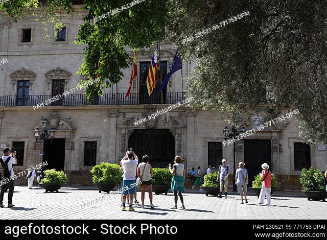 21 May 2023, Spain, Palma: Tourists take pictures of Palma City Hall. Lifeguards broke a strike after the company for which they work promised them the agreed...