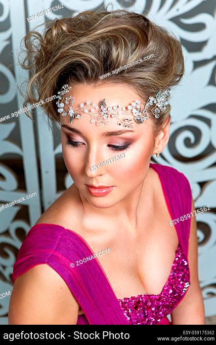 beautiful blond young woman in purple wedding gown. bride with fashion hairstyle. studio shot