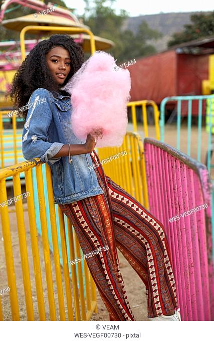 Portrait of smiling young woman with pink candyfloss at fair