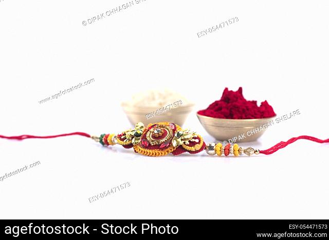 Indian festival: Raksha Bandhan background with an elegant Rakhi on a white background. A traditional Indian wrist band which is a symbol of love between...