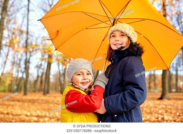 happy children with umbrella at autumn park