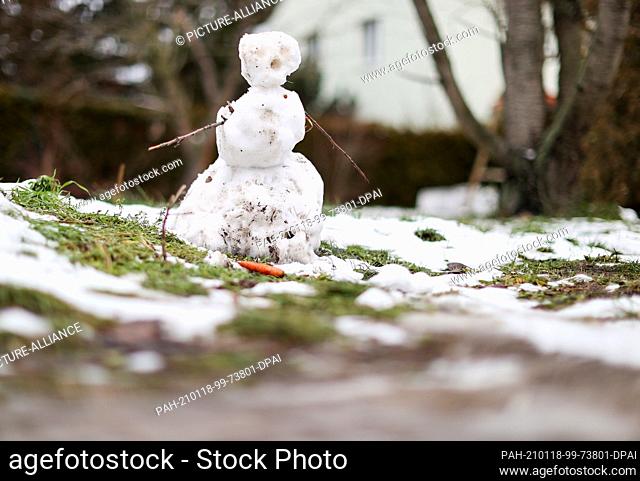 18 January 2021, Saxony, Leipzig: A melting snowman already has the carrot fallen out of his face. At the beginning of the new week, thaw has set in Saxony