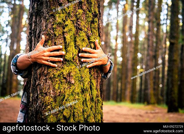 Ecology and environment concept with caucasian people woman hugging a green tree in the outdoor forest - nature and eco lifestyle - change the world - world's...